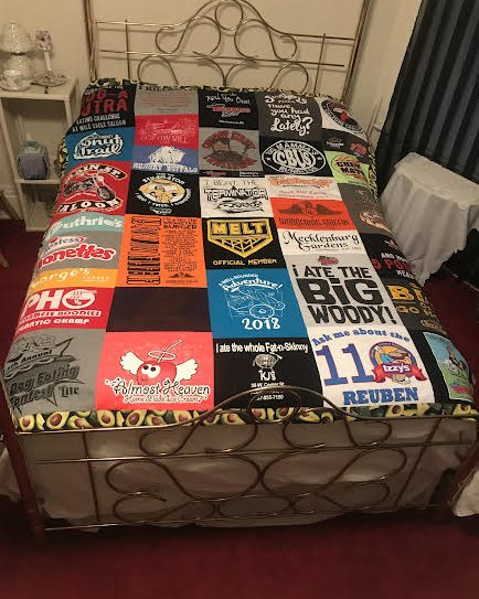 A t-shirt memory quilt on a bed