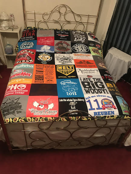 A t-shirt memory quilt on a bed