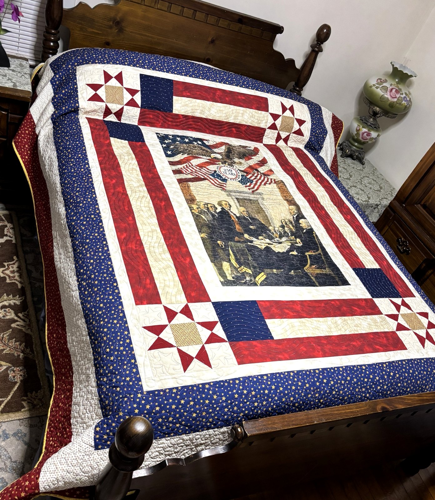Red, white and blue star quilt on a wooden bed